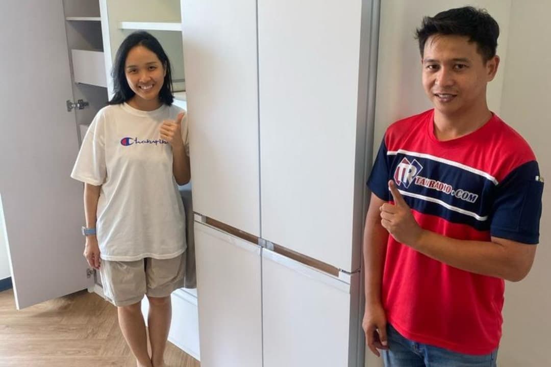 Tanradio 送货技师与年轻客户在她新家刚装好的 Toshiba 冰箱前合照。